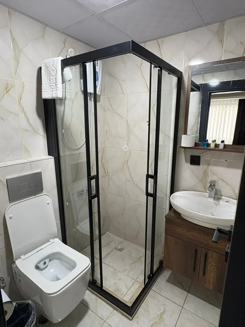Banyo: duşakabin, klozet ve mermer desenli seramik